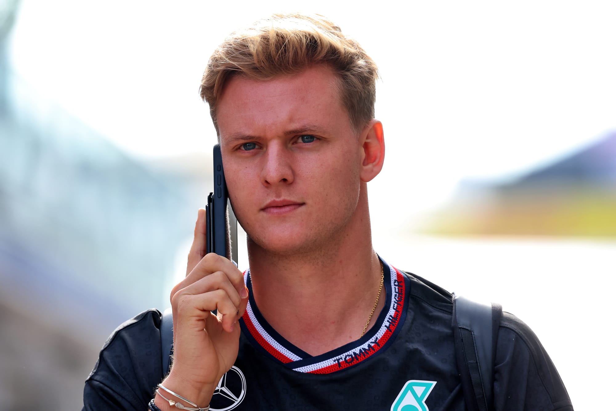 Image of Mick Schumacher holding a mobile phone at Austin, 2024