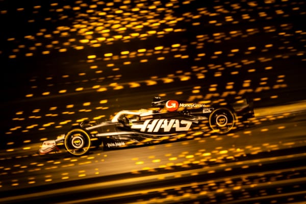 Kevin Magnussen's Haas is showered by light in a side-on image from F1 testing in Bahrain, 2024