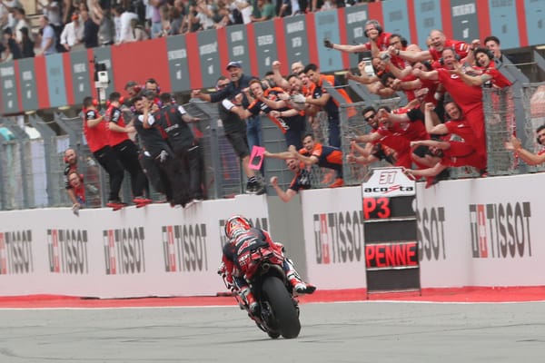 Pedro Acosta's crew hold out a board to celebrate his podium at Portimao as he crosses the finish line